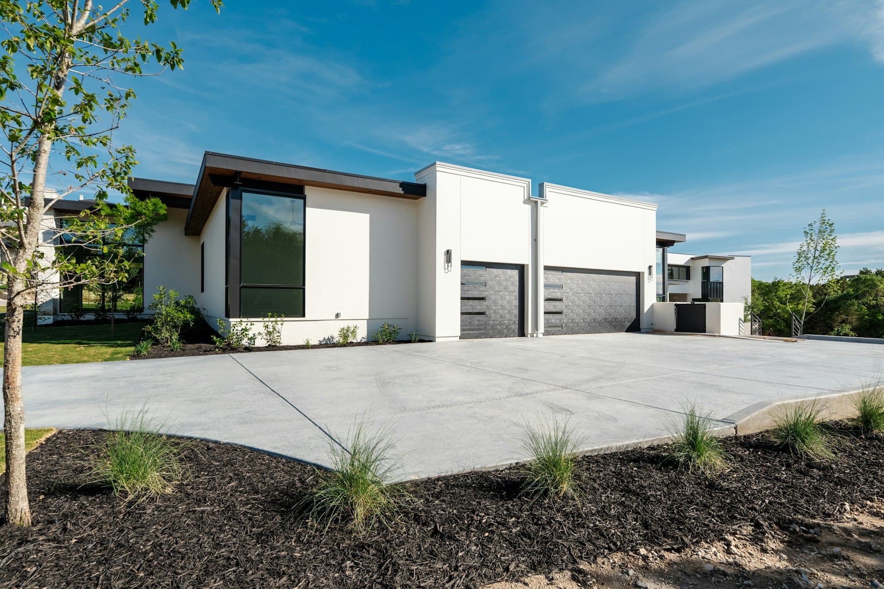 Example of a modern home with a large, freshly poured concrete driveway